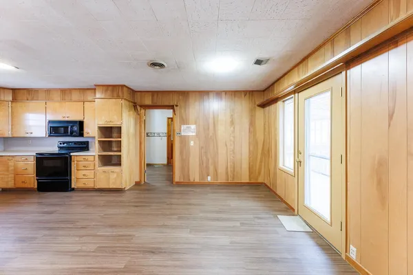 a view of kitchen with stainless steel appliances kitchen island wooden floor and window