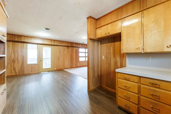 a view of a kitchen with wooden floor and cabinets