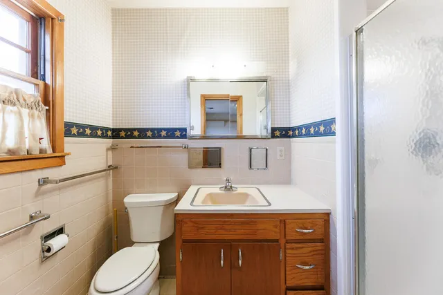 a bathroom with a sink a toilet and mirror