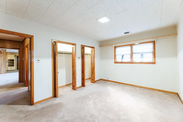 an empty room with windows and closet