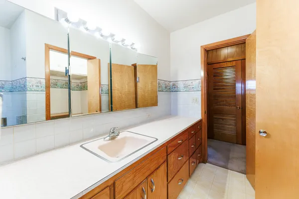 a bathroom with a tub sink and mirror