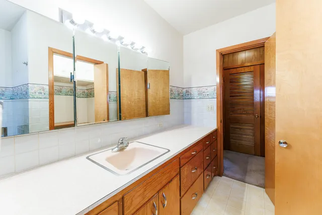 a bathroom with a tub sink and mirror