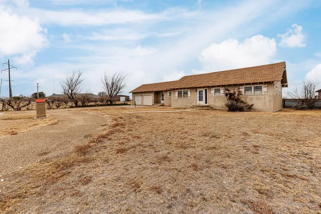 a view of house with yard and car parked