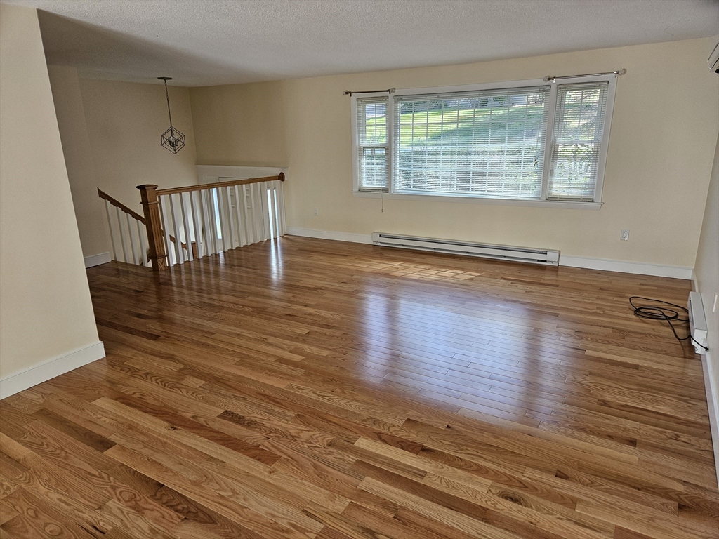 135 Walker Pond Road Sturbridge, MA 01566 - Photo 7 of 16 a view of an empty room with wooden floor and a window