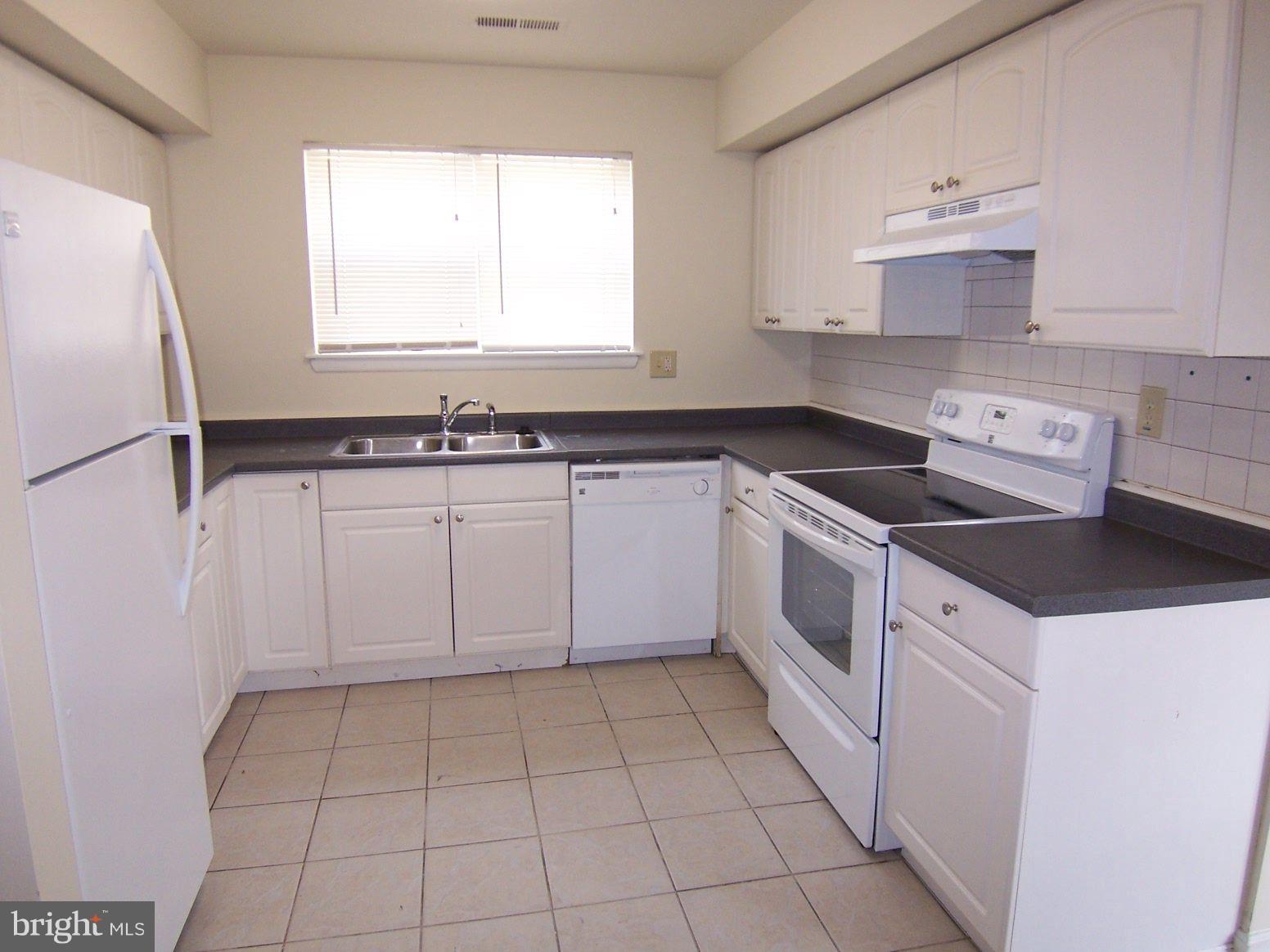 309 Laburnum Road Edgewood, MD 21040 - Photo 11 of 19 a white kitchen with a sink a stove top oven and white cabinets