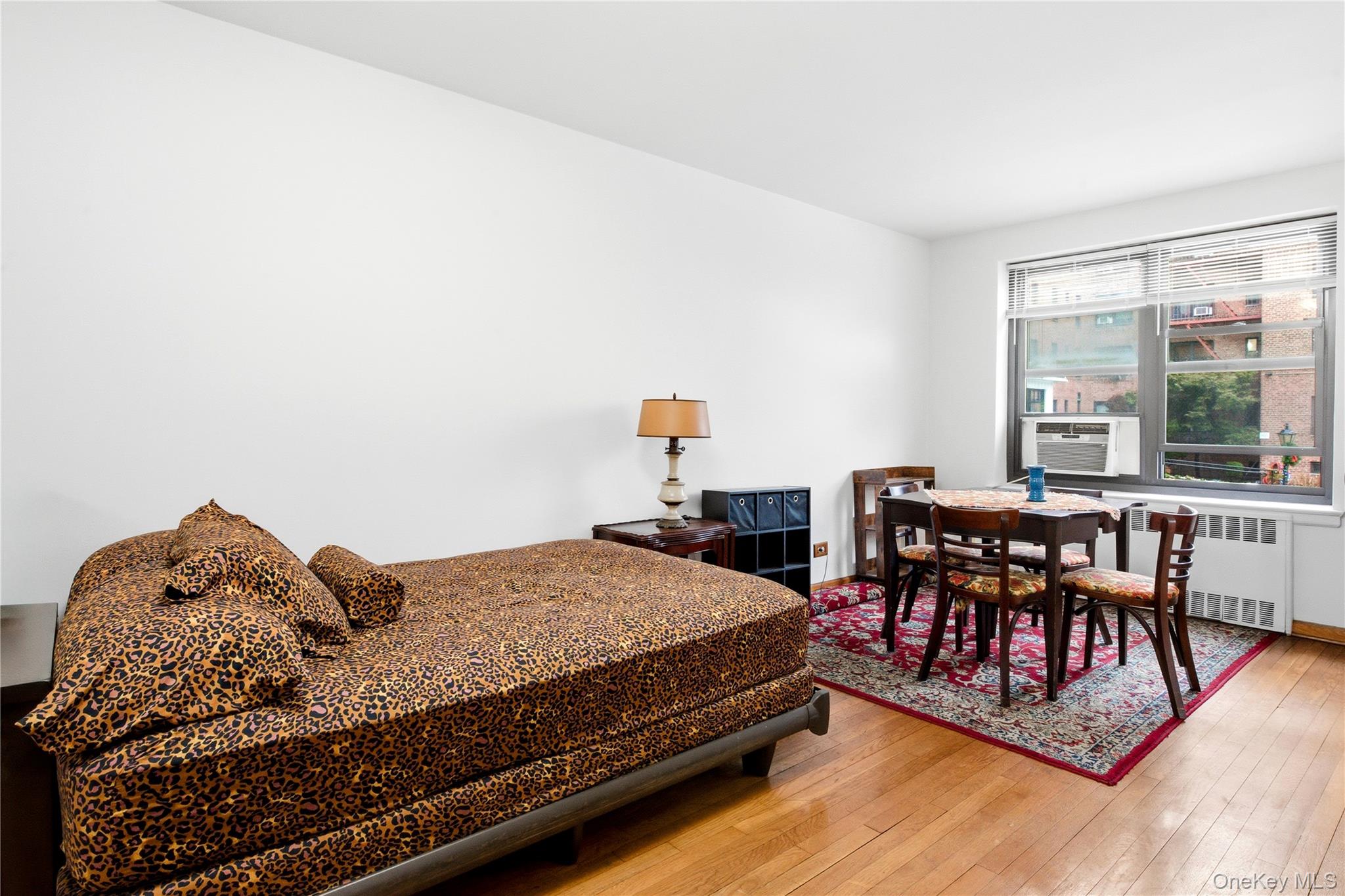 100-11 67th Road, Unit 107 Queens, NY 11375 - Photo 13 of 24 a bedroom with a bed and a table in it