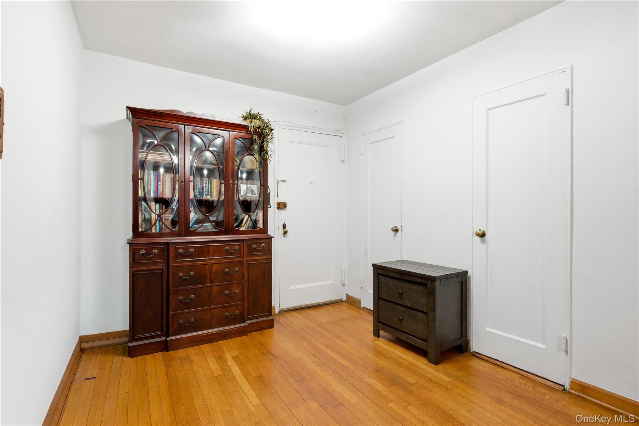 100-11 67th Road, Unit 107 Queens, NY 11375 - Photo 5 of 24 a living room with stainless steel appliances kitchen island a bed and cabinets
