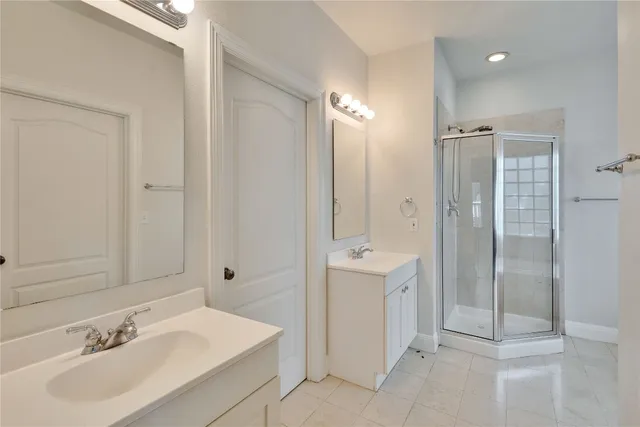 a bathroom with a sink shower and a mirror