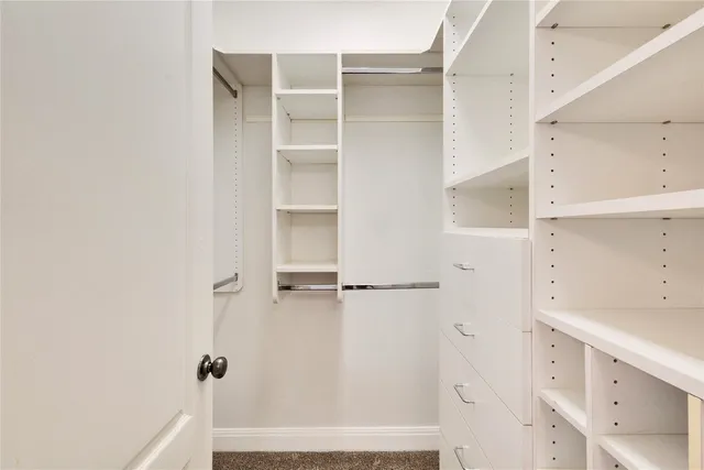 a view of walk in closet with empty racks