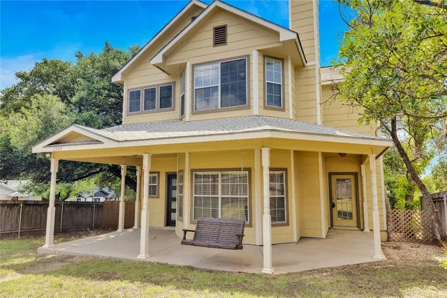 a front view of a house with a yard chairs and floor to ceiling window