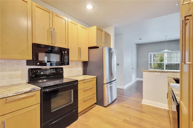 a kitchen with stainless steel appliances granite countertop a refrigerator stove and sink