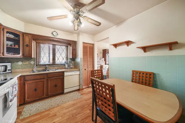 a kitchen with granite countertop a dining table chairs stainless steel appliances and cabinets