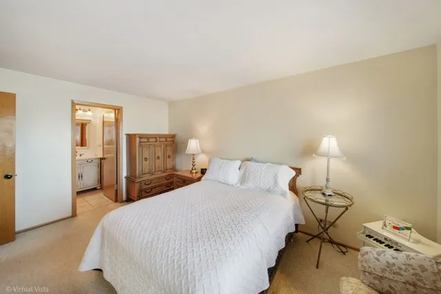 a bedroom with a bed and dresser with mirror