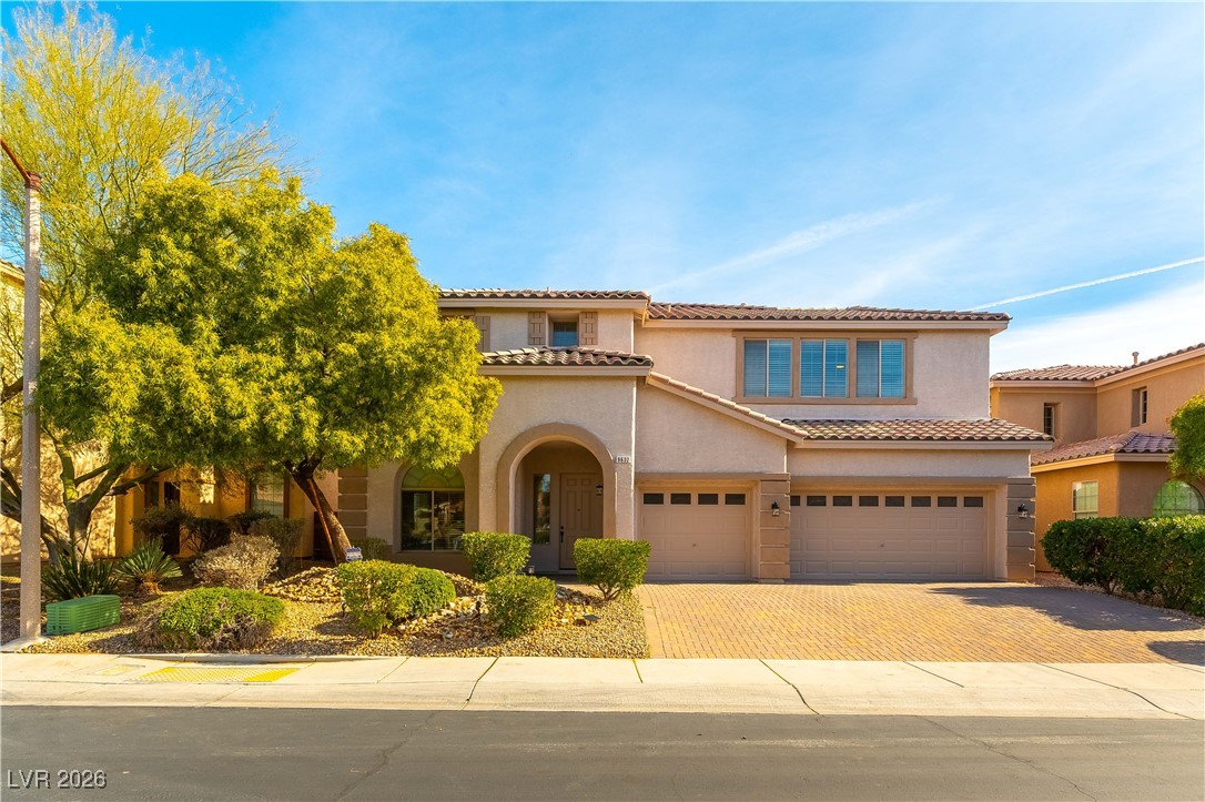 9632 Staff Lane Las Vegas, NV 89178 - Photo 1 of 53 Mediterranean / spanish house featuring stucco siding, an attached garage, decorative driveway, and a tile roof