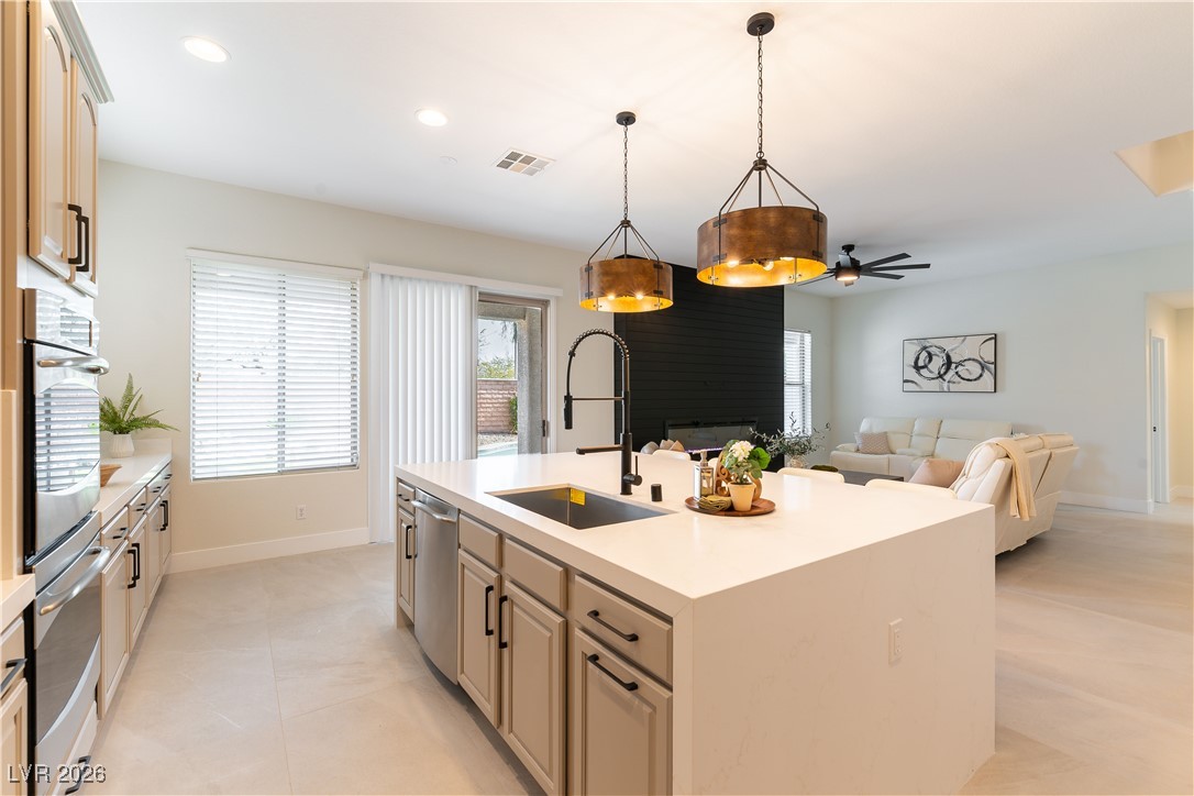 9632 Staff Lane Las Vegas, NV 89178 - Photo 53 of 53 Kitchen featuring a fireplace, open floor plan, appliances with stainless steel finishes, a center island with sink, and pendant lighting