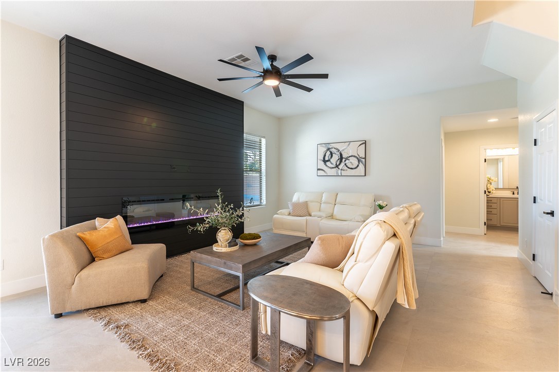 9632 Staff Lane Las Vegas, NV 89178 - Photo 10 of 53 Living area with ceiling fan and a glass covered fireplace