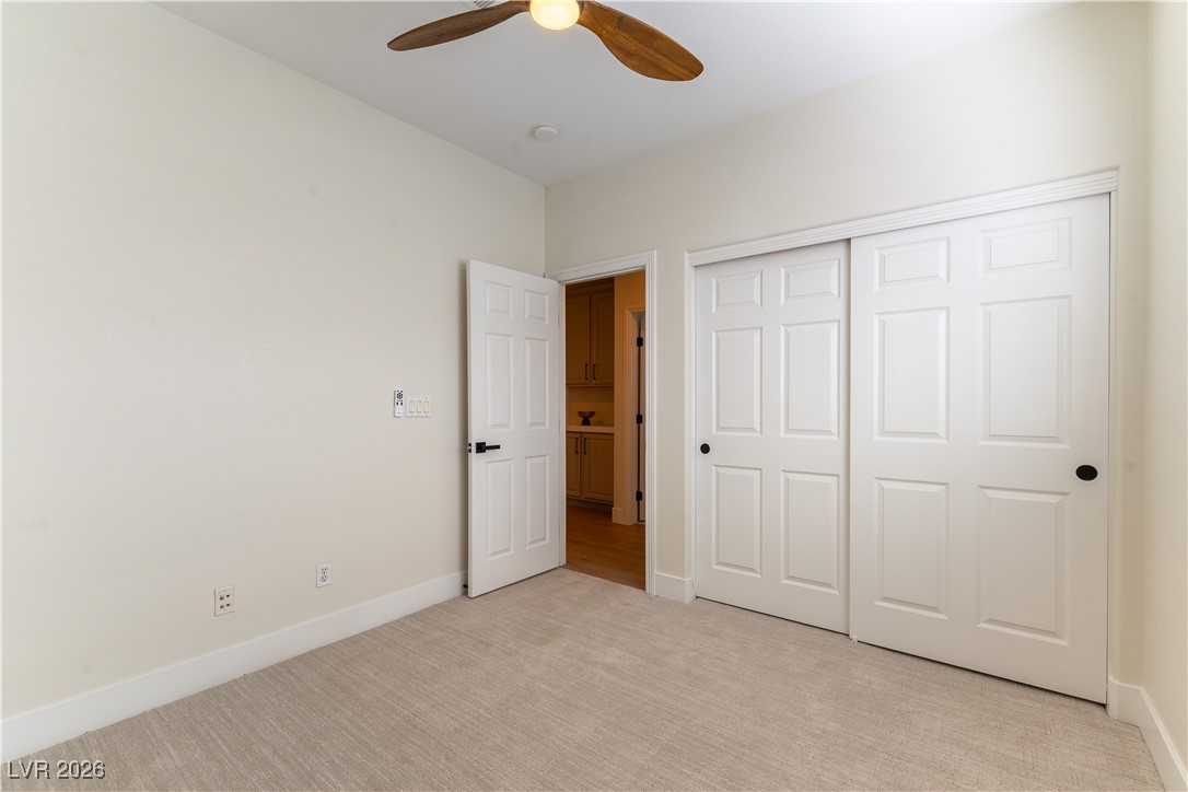 9632 Staff Lane Las Vegas, NV 89178 - Photo 22 of 53 Unfurnished bedroom with light colored carpet, ceiling fan, and a closet