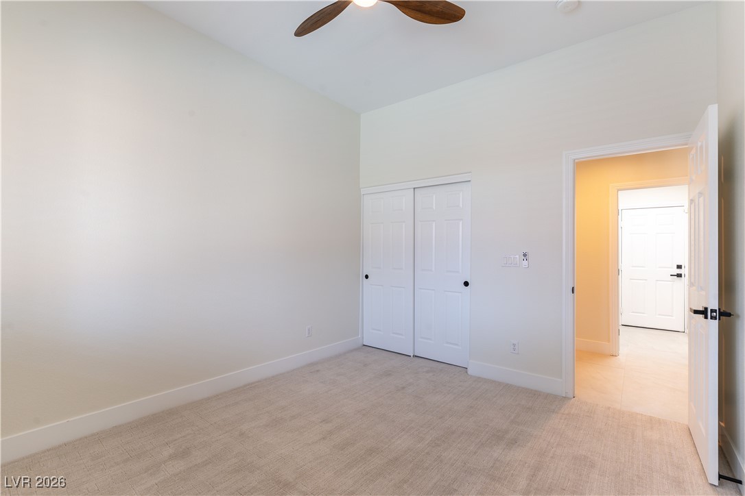 9632 Staff Lane Las Vegas, NV 89178 - Photo 29 of 53 Unfurnished bedroom featuring light carpet, a closet, a ceiling fan, and vaulted ceiling