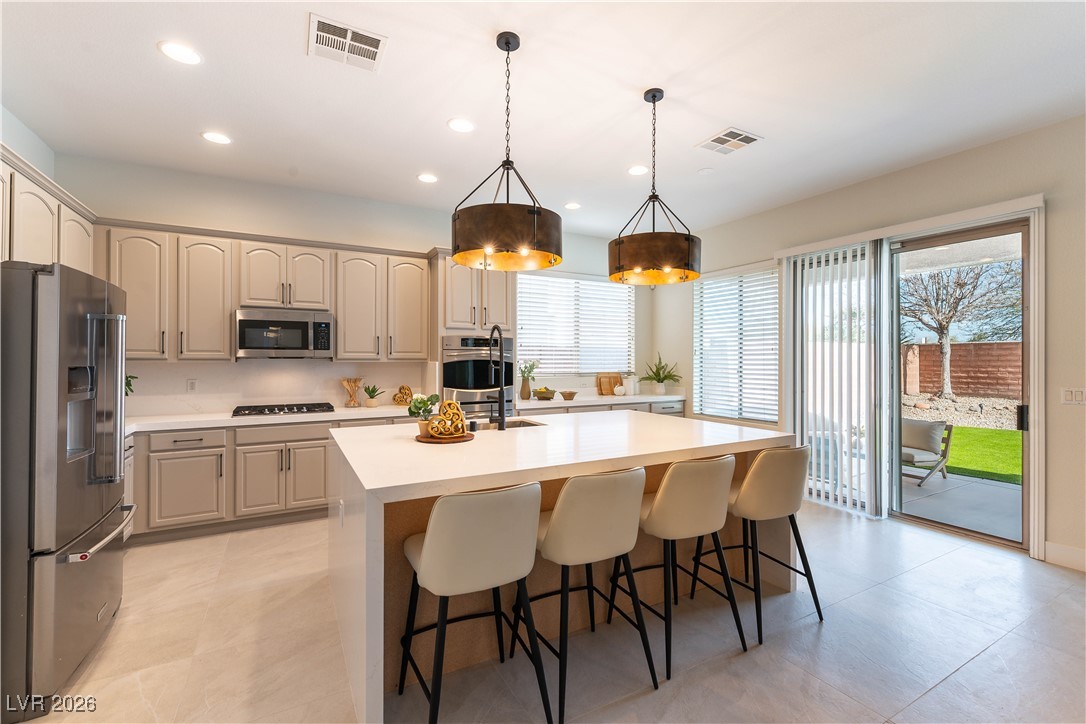 9632 Staff Lane Las Vegas, NV 89178 - Photo 8 of 53 Kitchen with pendant lighting, stainless steel appliances, recessed lighting, a center island with sink, and a kitchen breakfast bar