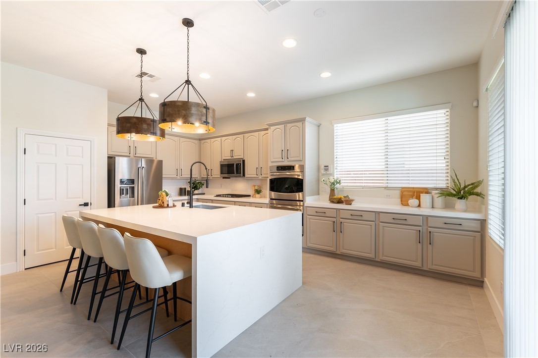 9632 Staff Lane Las Vegas, NV 89178 - Photo 9 of 53 Kitchen with hanging light fixtures, a kitchen island with sink, a breakfast bar, stainless steel appliances, and recessed lighting