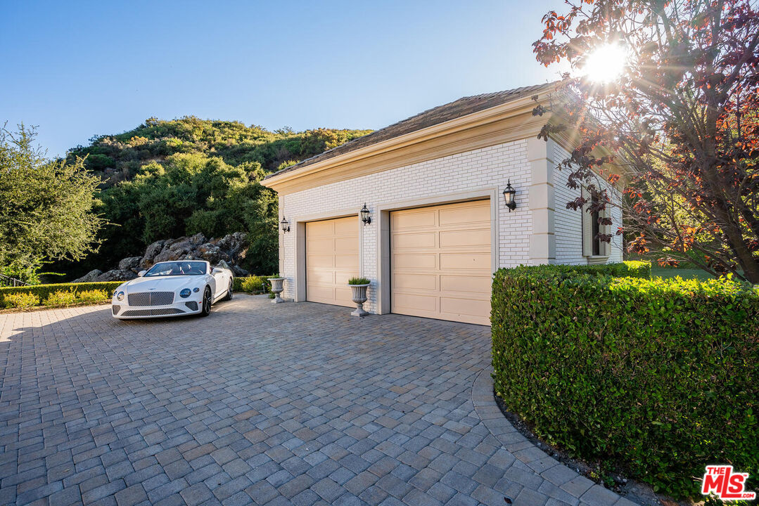 3063 West Stafford Road Thousand Oaks, CA 91361 - Photo 19 of 19 a car parked in front of a house with a large tree