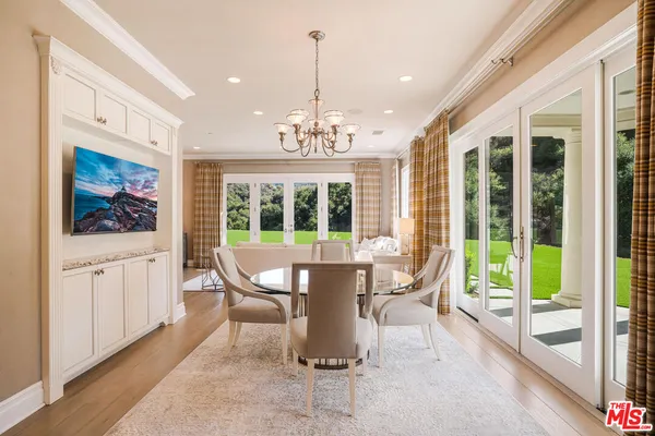 a dining room with wooden floor and windows