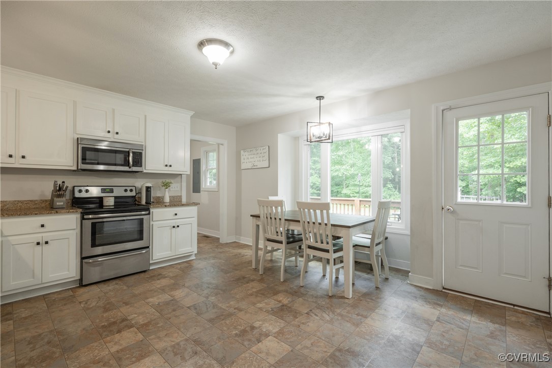 1315 Mill Road Aylett, VA 23086 - Photo 18 of 33 a kitchen with stainless steel appliances granite countertop a stove top oven a sink a dining table and chairs with wooden floor