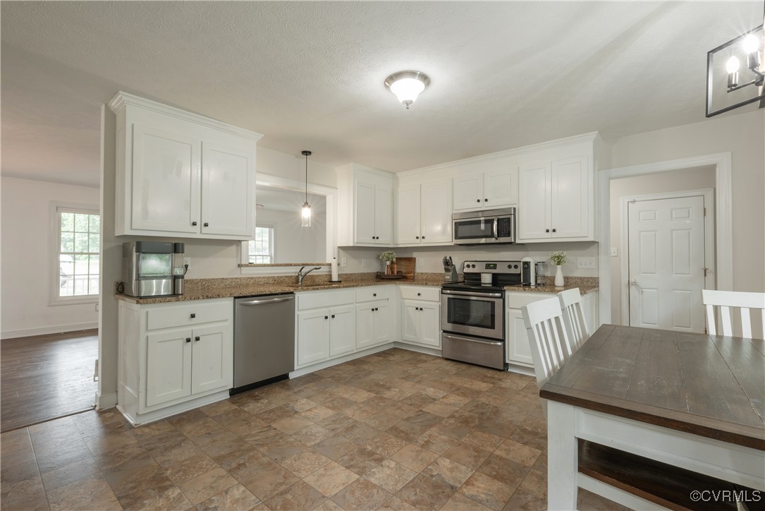 1315 Mill Road Aylett, VA 23086 - Photo 19 of 33 a kitchen with granite countertop white cabinets and stainless steel appliances