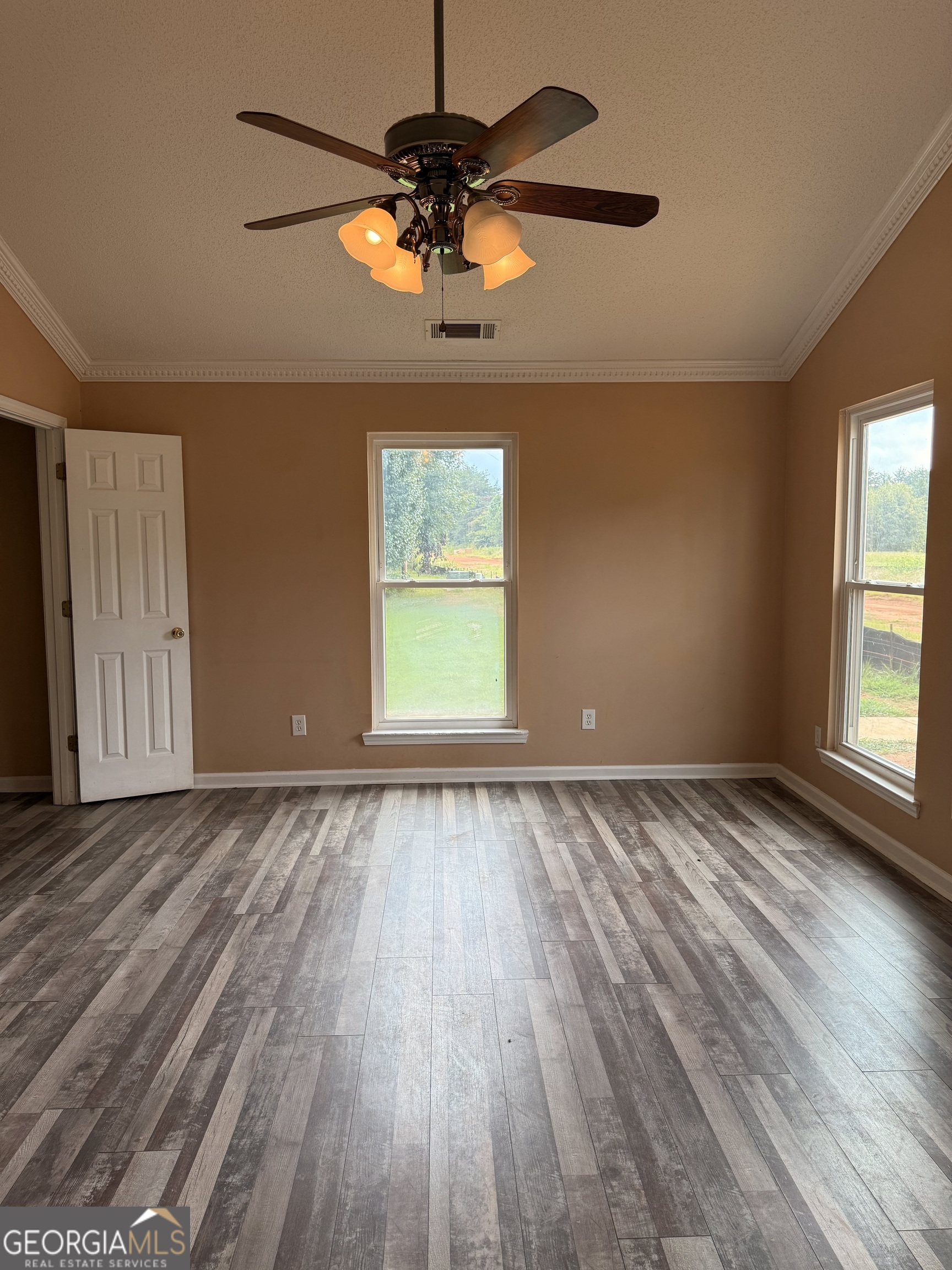323 Snapping Shoals Road McDonough, GA 30252 - Photo 11 of 20 an empty room with wooden floor chandelier fan and windows