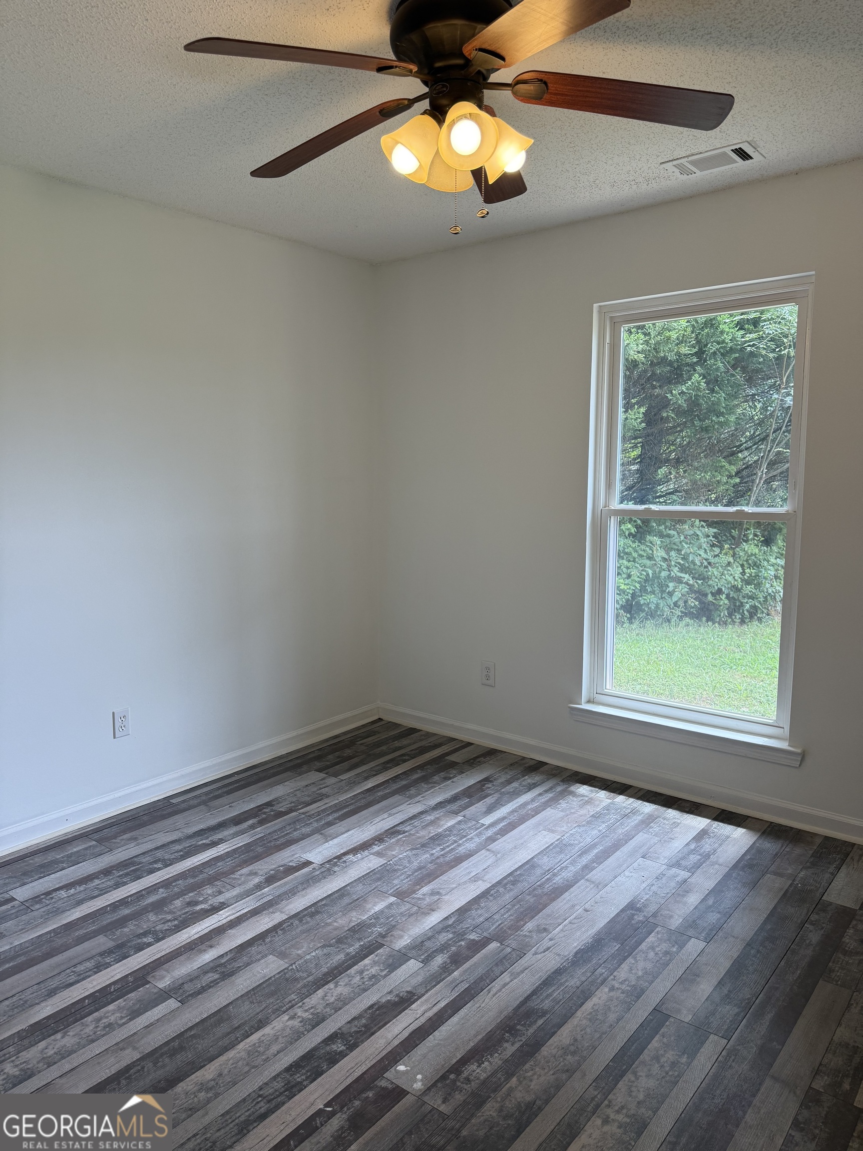 323 Snapping Shoals Road McDonough, GA 30252 - Photo 12 of 20 a view of empty room with wooden floor and fan