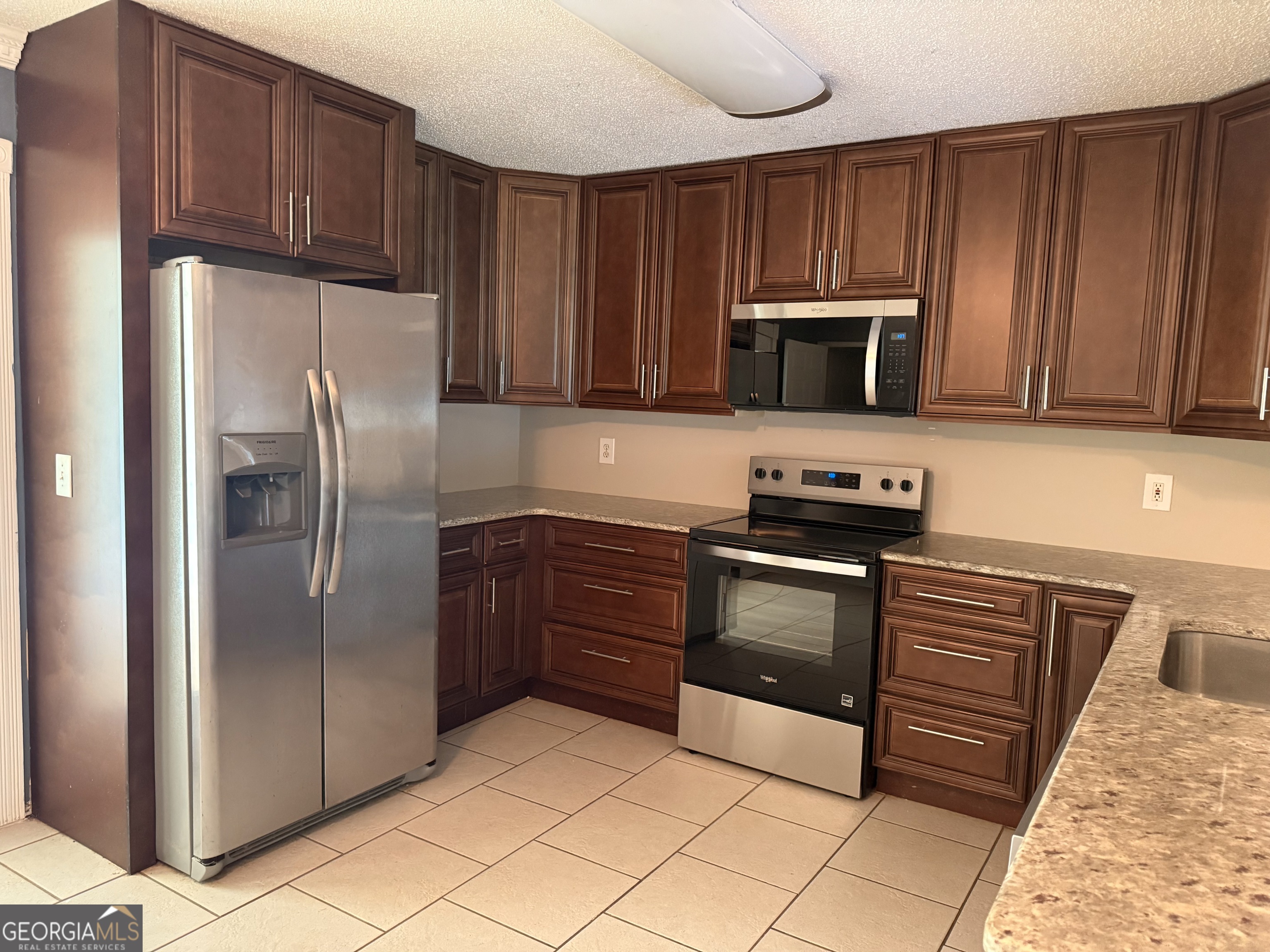 323 Snapping Shoals Road McDonough, GA 30252 - Photo 10 of 20 a kitchen with granite countertop wooden cabinets and stainless steel appliances