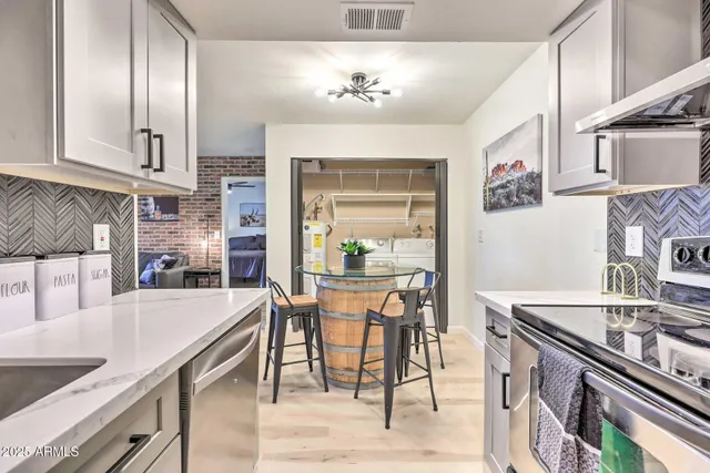 a kitchen with stainless steel appliances granite countertop a stove a sink dishwasher and a refrigerator with wooden floor