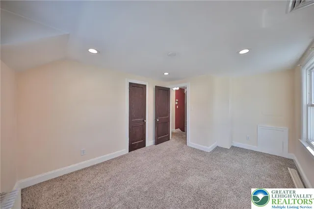wooden floor fireplace and windows in an empty room