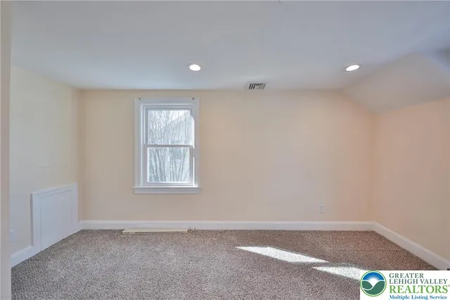 a view of a hallway with wooden floor and windows