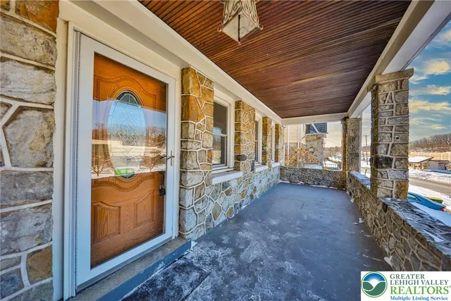 a view of a hallway with wooden floor and a kitchen