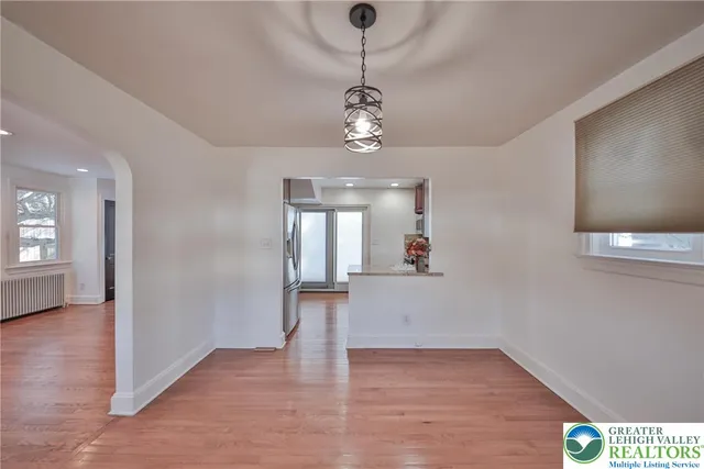 a view of a kitchen with wooden floor and a refrigerator