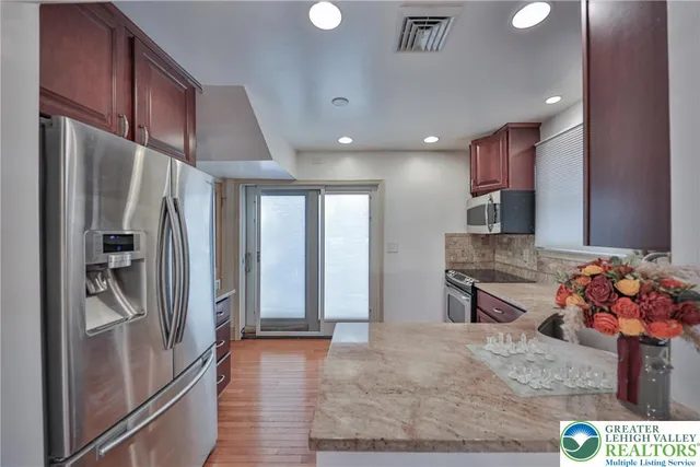 a kitchen with stainless steel appliances granite countertop a refrigerator and a sink