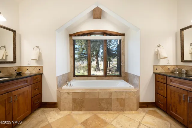 a spacious bathroom with a bathtub sink and mirror