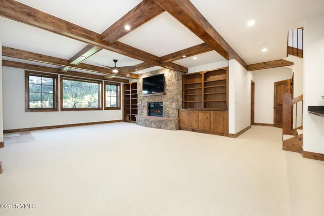 an empty room with a fireplace and windows