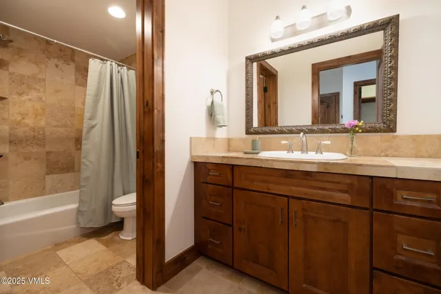 a bathroom with a double vanity sink mirror and a bathtub
