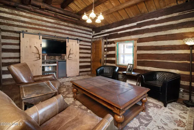 a living room with furniture a flat screen tv and kitchen view