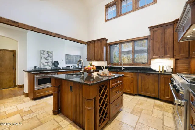 a kitchen with stainless steel appliances granite countertop a stove a sink and a microwave