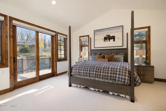 a bedroom with a bed painting and a large window