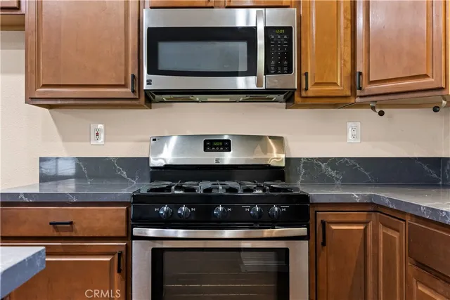 a kitchen with stainless steel appliances granite countertop white cabinets and a stove top oven