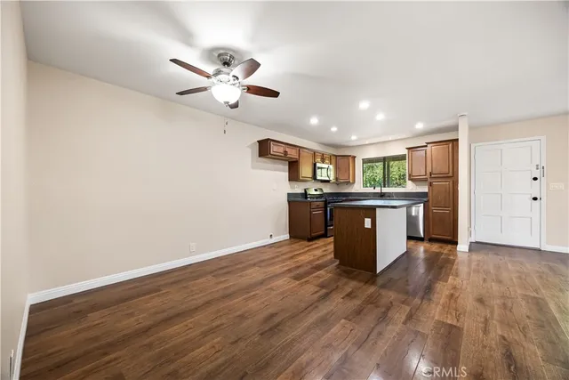 a kitchen with stainless steel appliances granite countertop a sink cabinets and wooden floor
