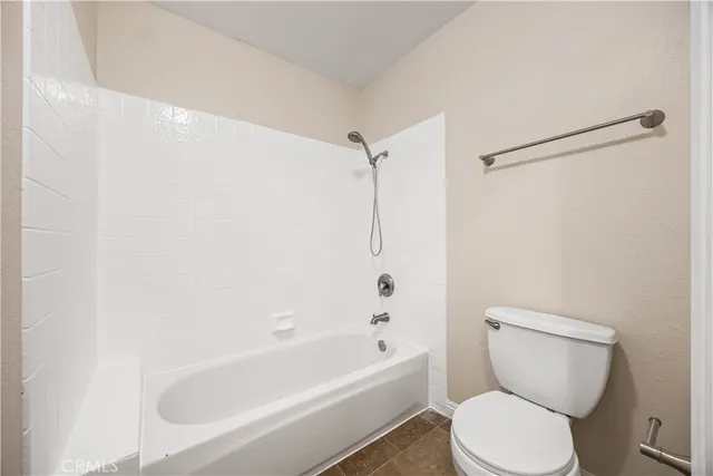a white toilet sitting next to a bathroom sink