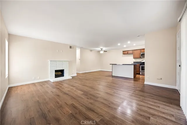a view of empty room with wooden floor and fireplace