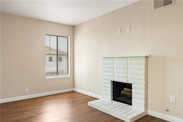 an empty room with windows and fireplace