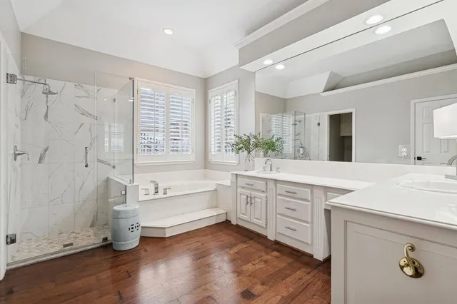 a spacious bathroom with a granite countertop tub a sink and a large mirror