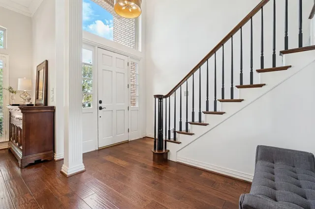 a view of a hallway with wooden floor and stairs
